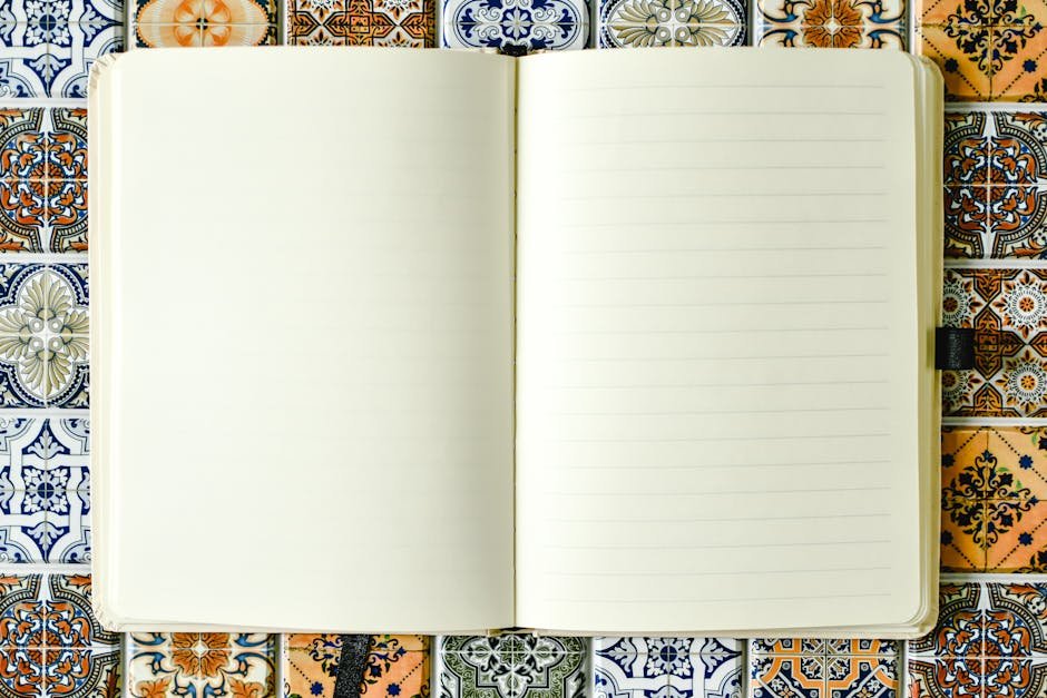 Blank lined notebook on a vibrant patterned tile background, perfect for creative use.